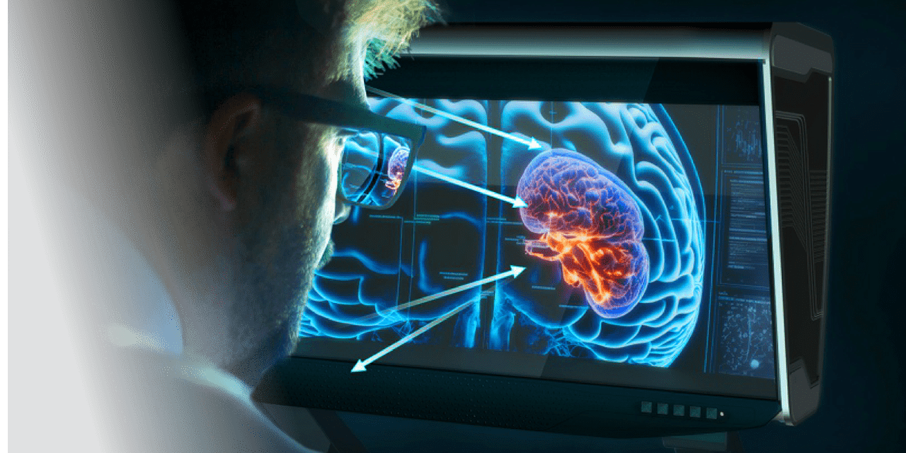 Scientist wearing glasses looks at a large monitor displaying a glowing blue brain with highlighted areas and arrows pointing to regions.