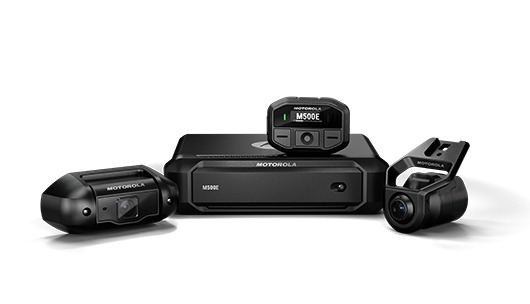 Motorola action camera kit on a white background: central hub with display flanked by two compact cameras.